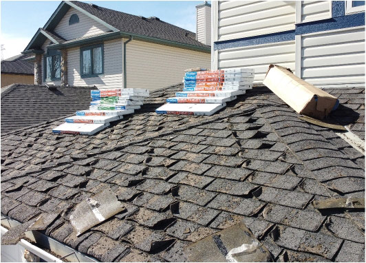 Boxes of new shingles on old roof ready for replacement