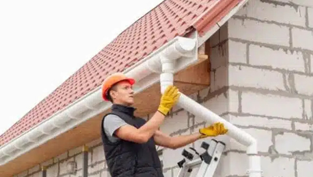 Man aligning downspouts